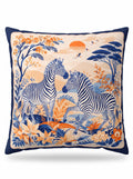 A square decorative throw pillow featuring a detailed safari illustration of two zebras, trees, flowers, birds, and a sunset in navy blue, orange, beige, and light blue.