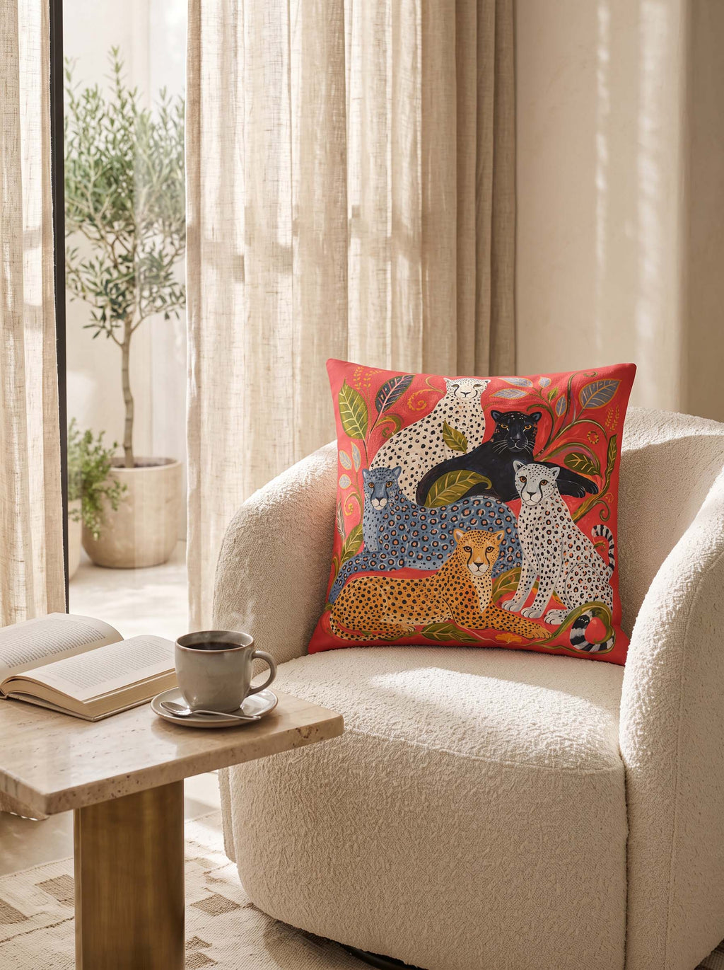 A square decorative throw pillow with a colorful animal print sits on a cream boucle armchair in a bright, modern living room setting.